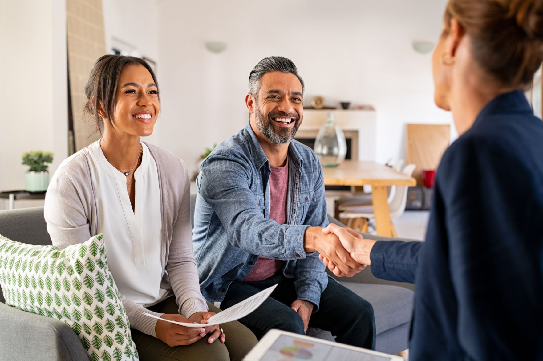 Multi-ethnic couple handshake with consultant at home